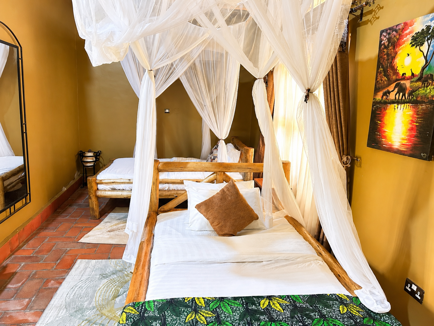 Imhotep banda canopy bed with elephant art decor at Warujojo Safari Lodge