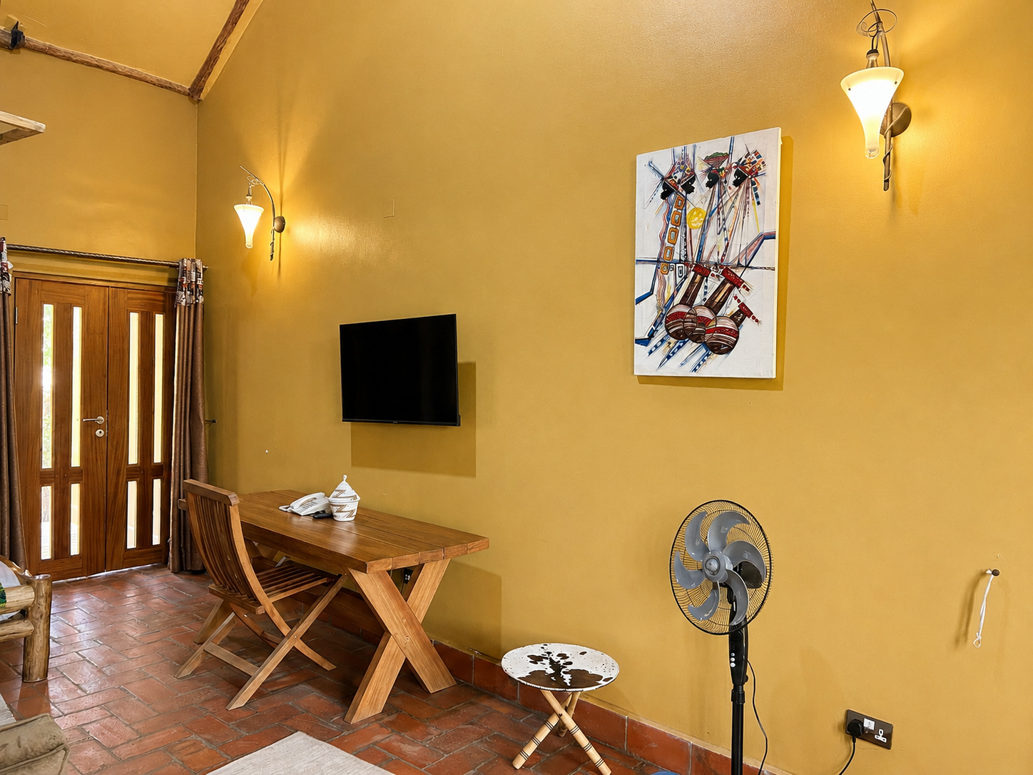 Imhotep banda lounge desk, TV and art corner at Warujojo Safari Lodge