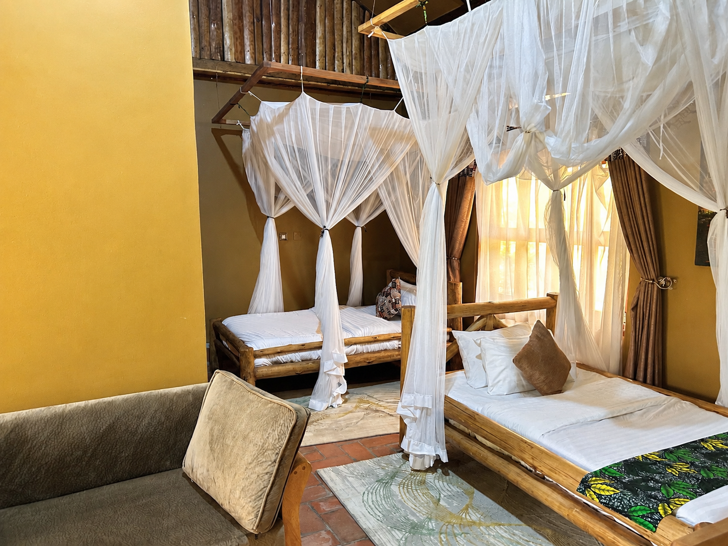 Imhotep banda twin canopy beds with lounge view at Warujojo Safari Lodge