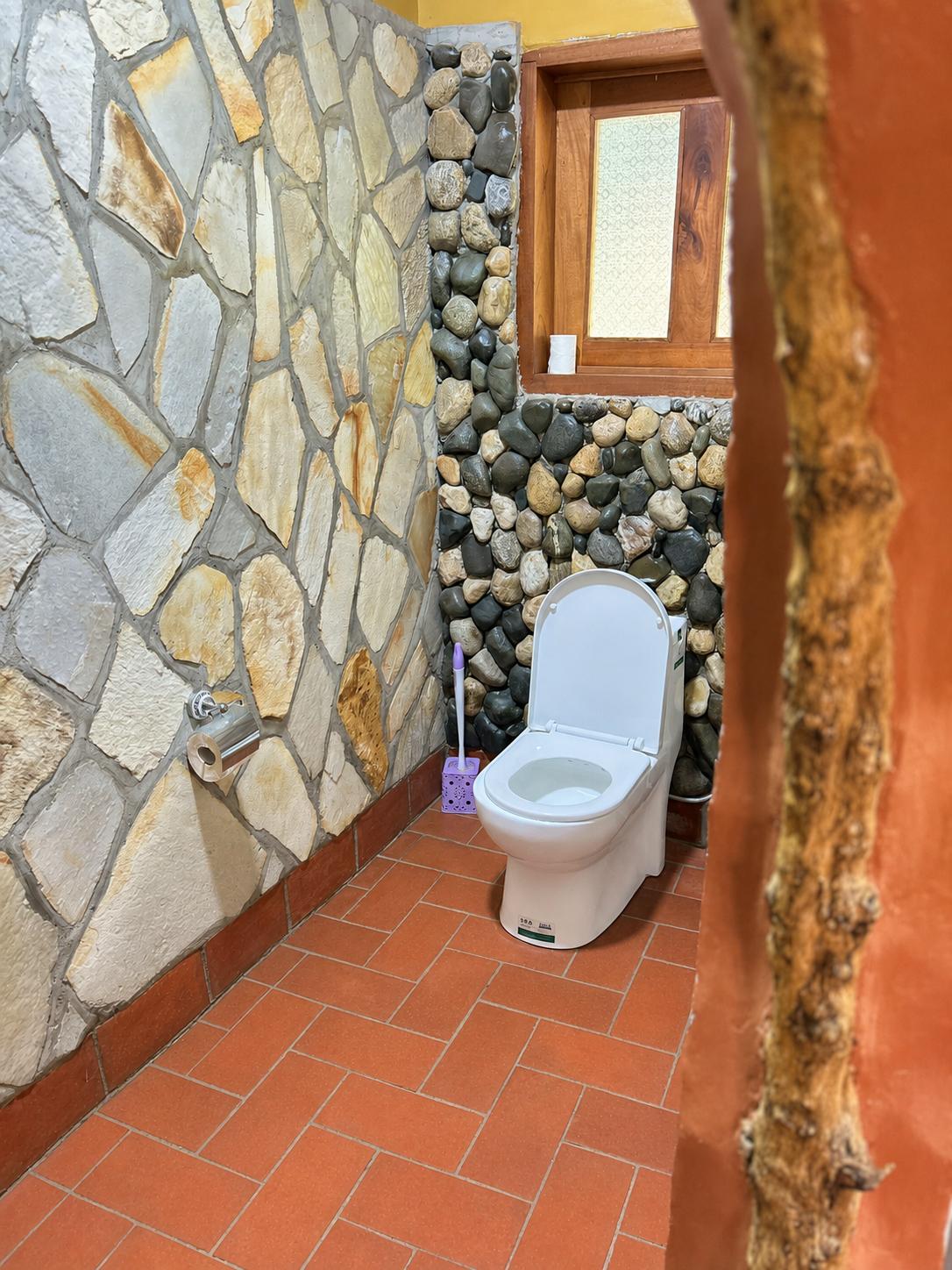 Rekemire banda ensuite toilet with stone wall at Warujojo Safari Lodge