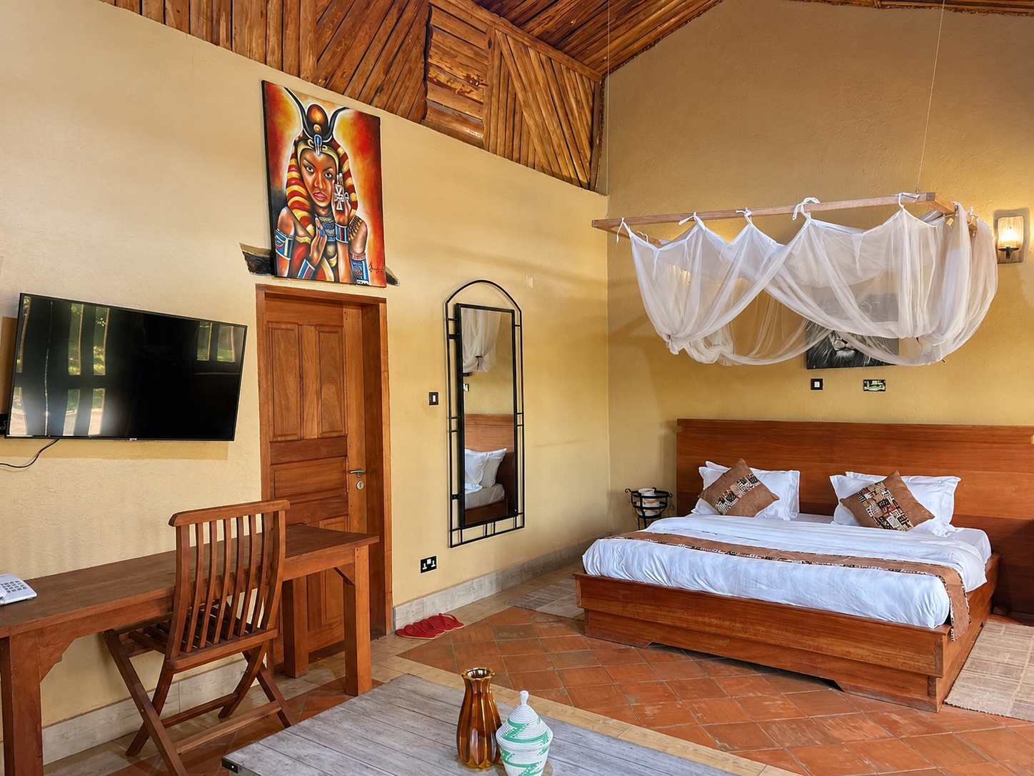 Saraunya banda bedroom with TV and desk at Warujojo Safari Lodge