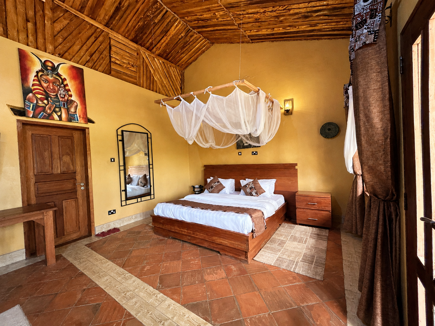 Saraunya banda canopy bed with artwork and decor at Warujojo Safari Lodge