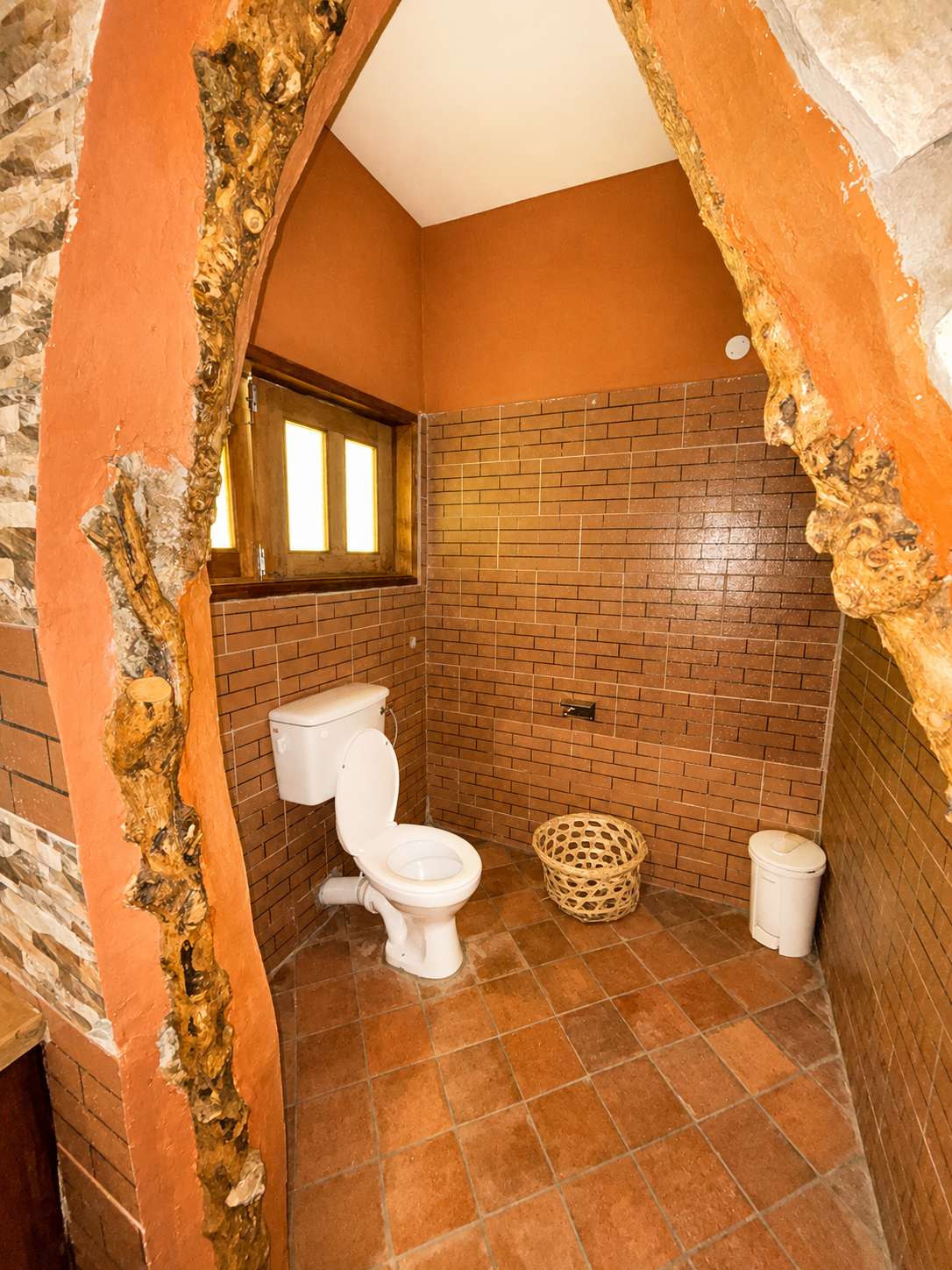 Saraunya banda rustic toilet room with archway at Warujojo Safari Lodge