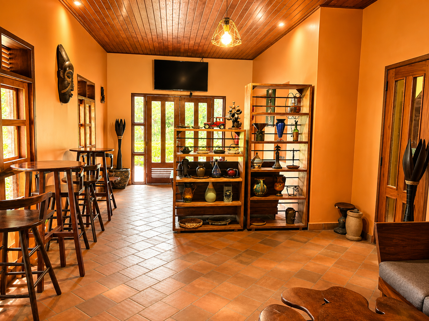 Curio shelf of pottery and carvings in the bar at Warujojo Safari Lodge