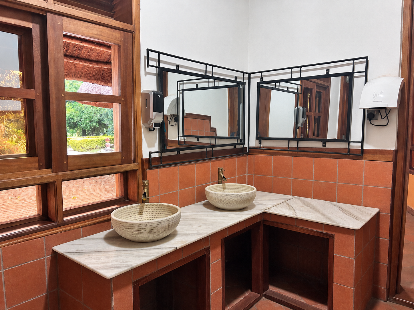 Twin basins and mirrors in the guest cloakroom at Warujojo Safari Lodge