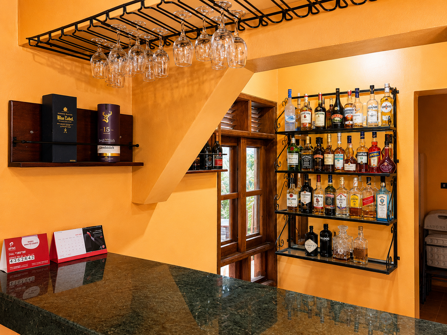 Hanging wine glass rack above the bar counter at Warujojo Safari Lodge