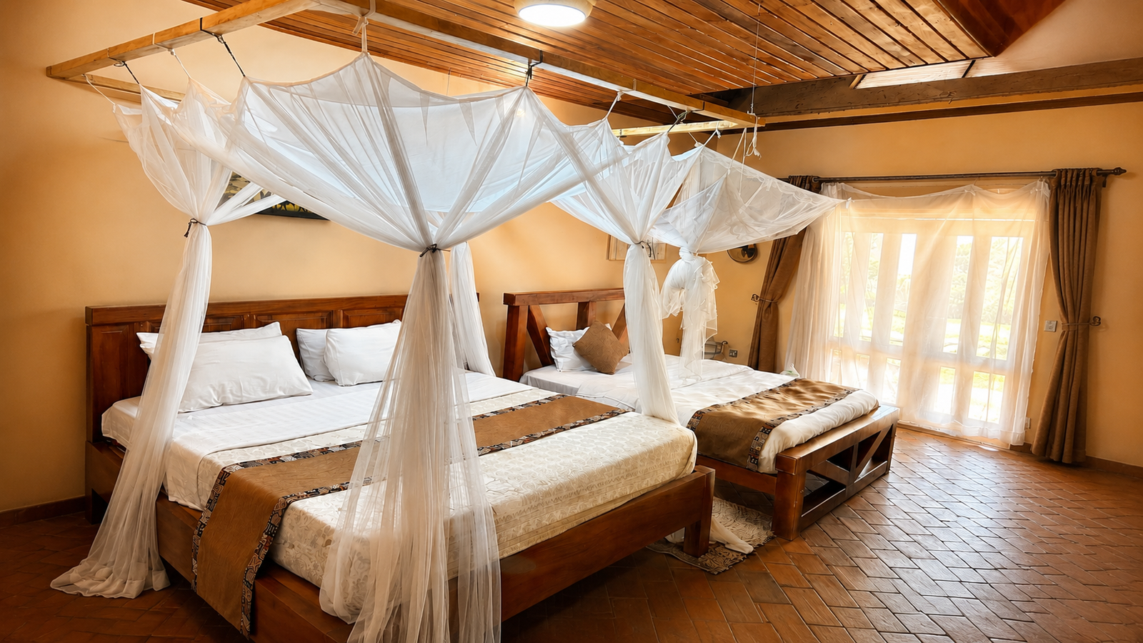 Hannibal cottage's twin four-poster beds under mosquito-net canopies, seen through the doorway at Warujojo Safari Lodge