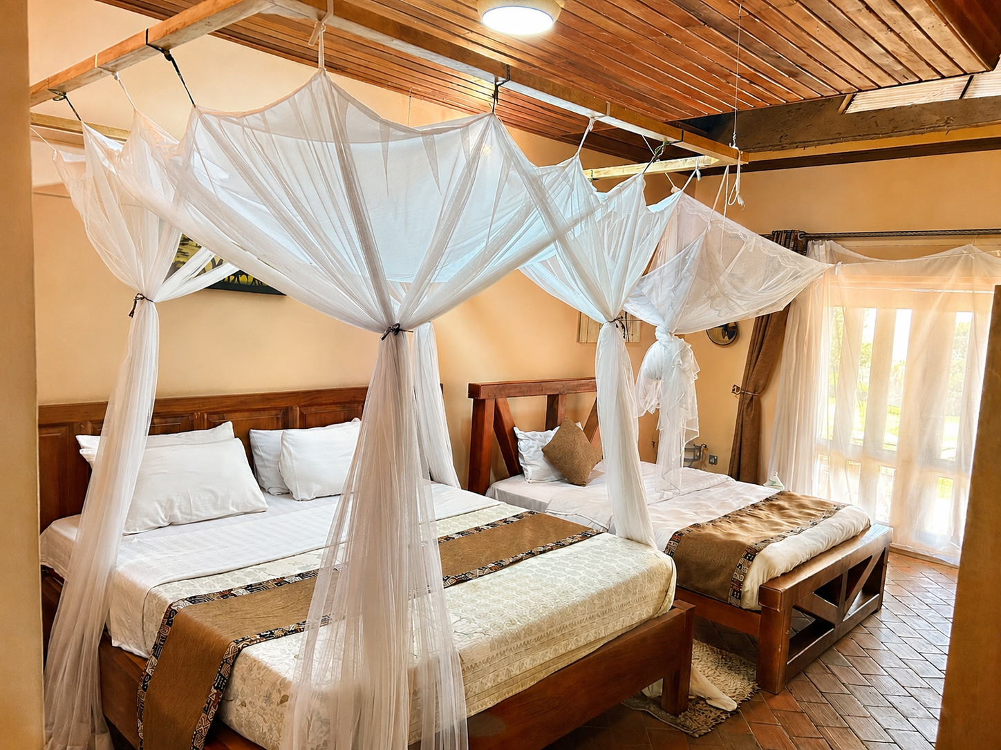 Hannibal cottage twin beds with canopy nets by the doorway at Warujojo Safari Lodge