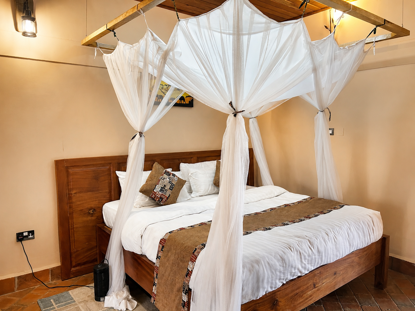 Kibalama cottage bedroom with canopy bed and lantern at Warujojo Safari Lodge