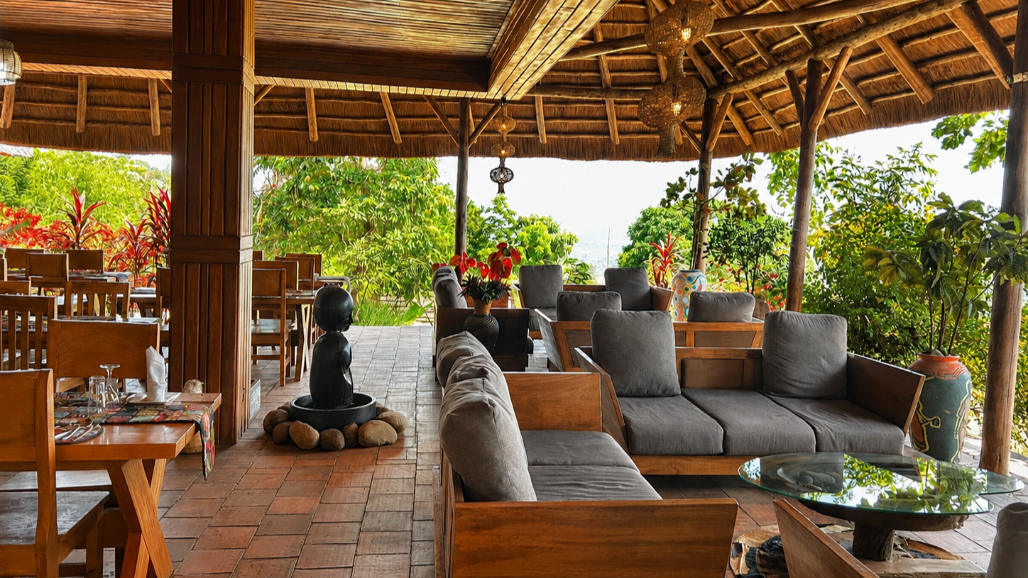 Open-air dining space with timber tables under thatch at Warujojo Safari Lodge
