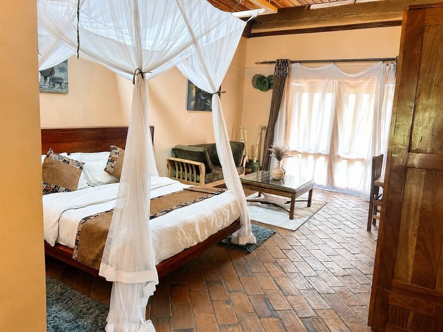 Amina cottage at Warujojo Safari Lodge: canopied four-poster king bed and sitting area