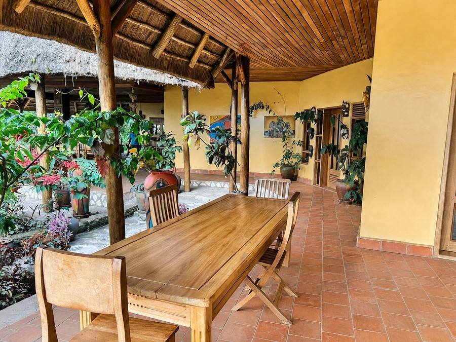 A long dining table on the veranda looking out over the savanna