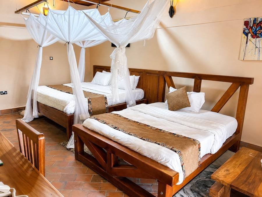 Hannibal twin cottage at Warujojo Safari Lodge: two four-poster beds under mosquito nets