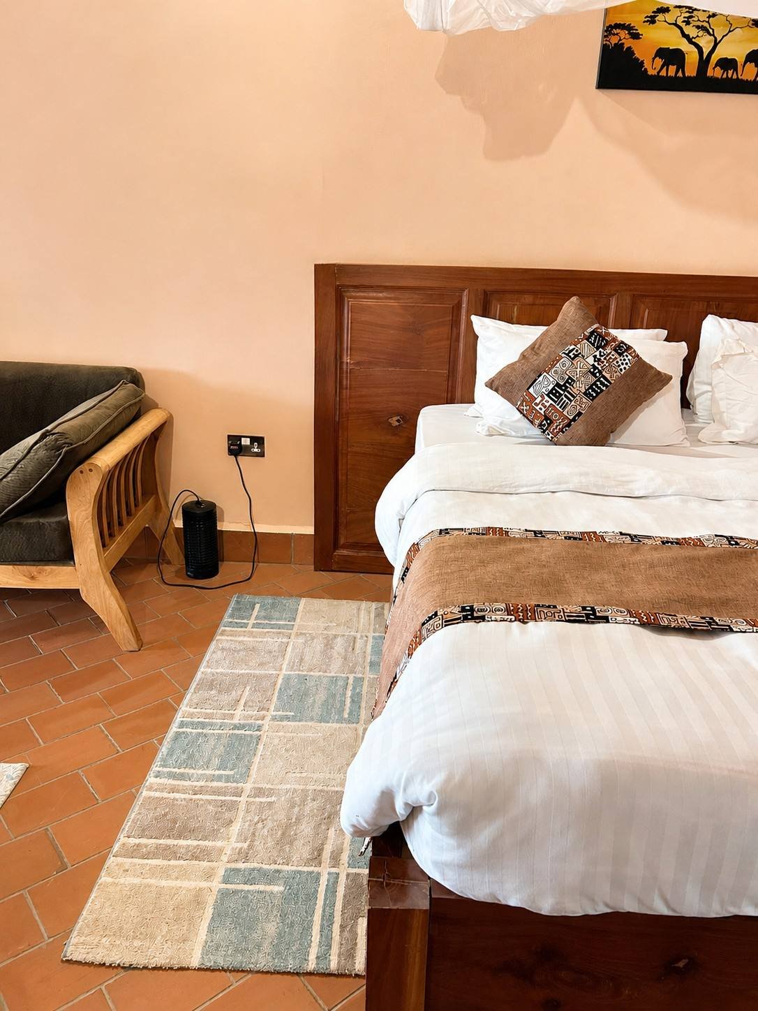 Guest-ready king bed with crisp linens and a woven runner at Warujojo Safari Lodge