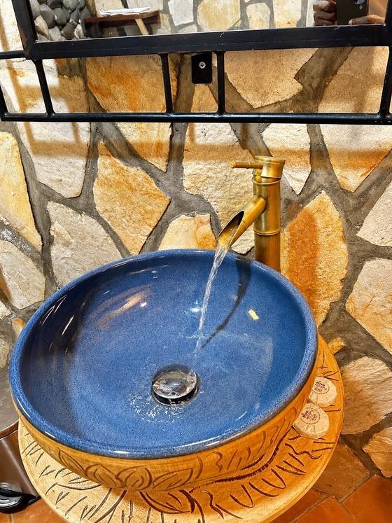 Water running into the stone basin in Menelik cottage at Warujojo Safari Lodge
