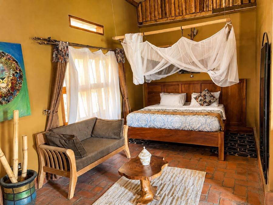 Canopied bed under a white mosquito net in Rekemire banda at Warujojo Safari Lodge