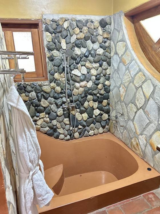 Sunken terracotta tub and shower in Rekemire banda at Warujojo Safari Lodge